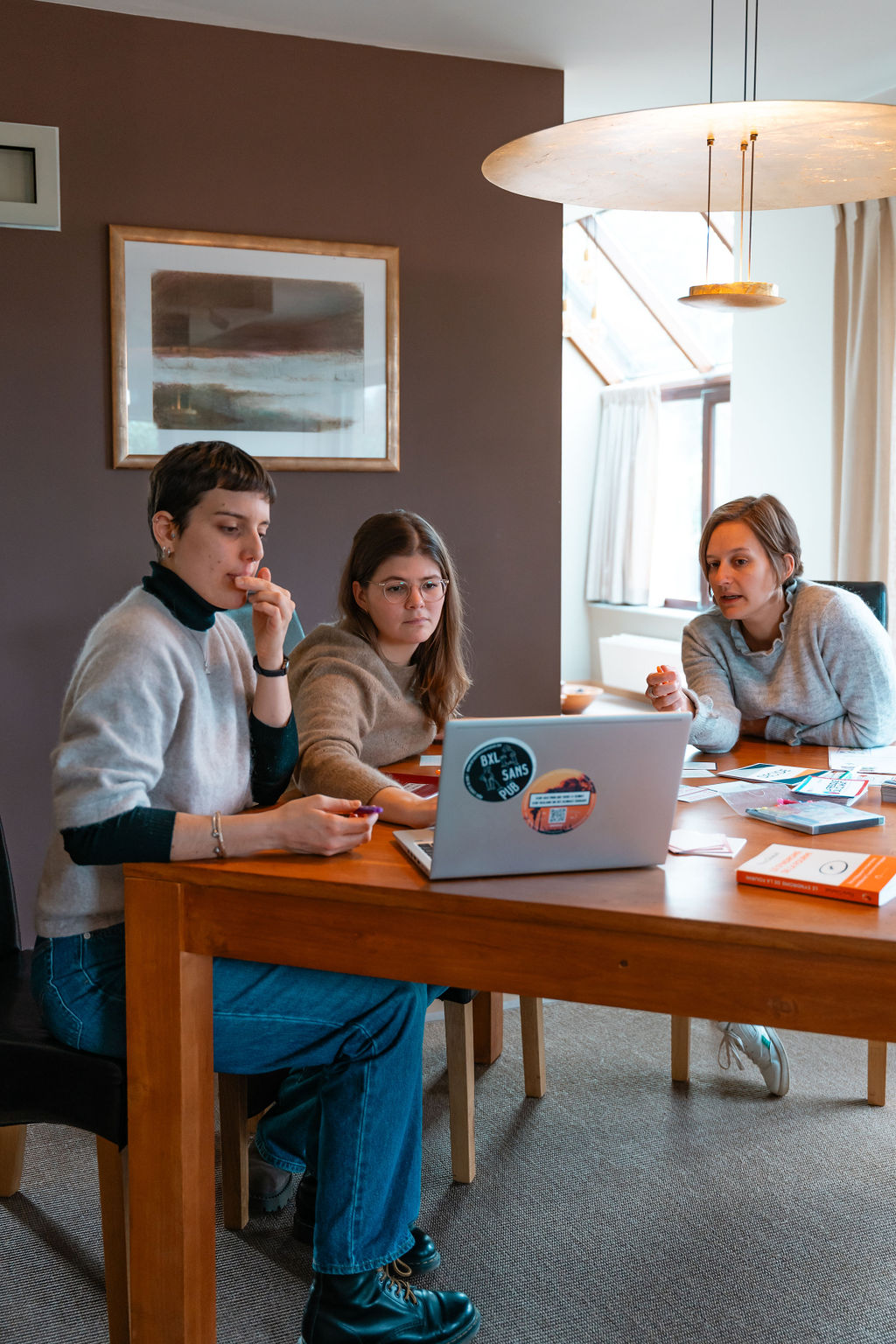 Trois collaboratrices en séance de travail autour d’un ordinateur portable